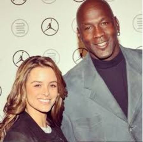 Yvette Prieto in a black dress with husband Michael Jordan at an event.